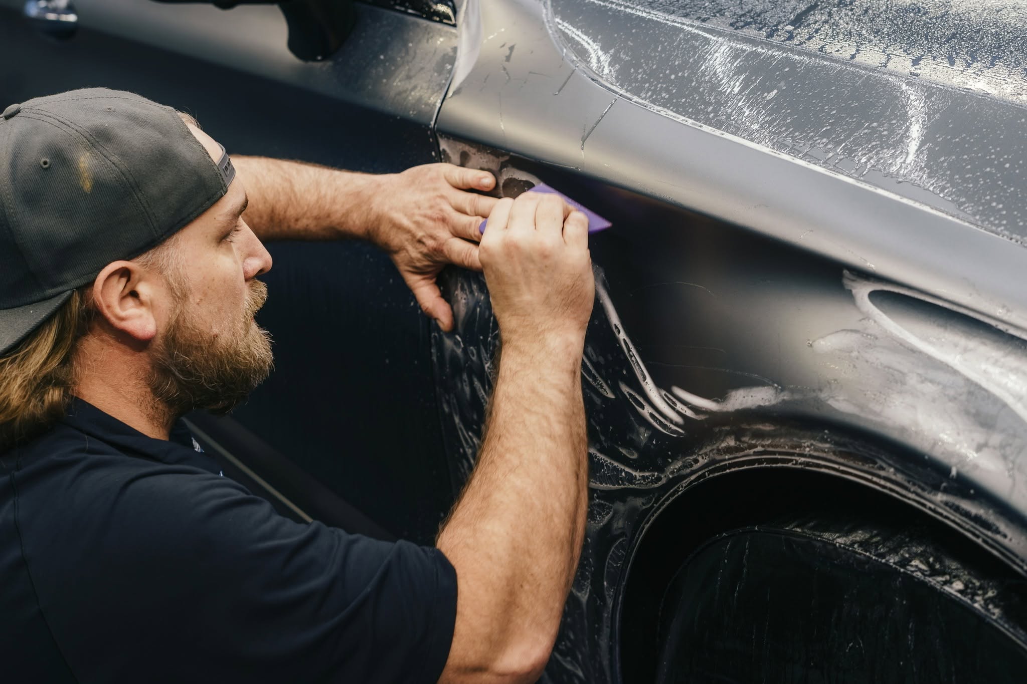 Elite Protective Film technician installing paint protection film on a vehicle